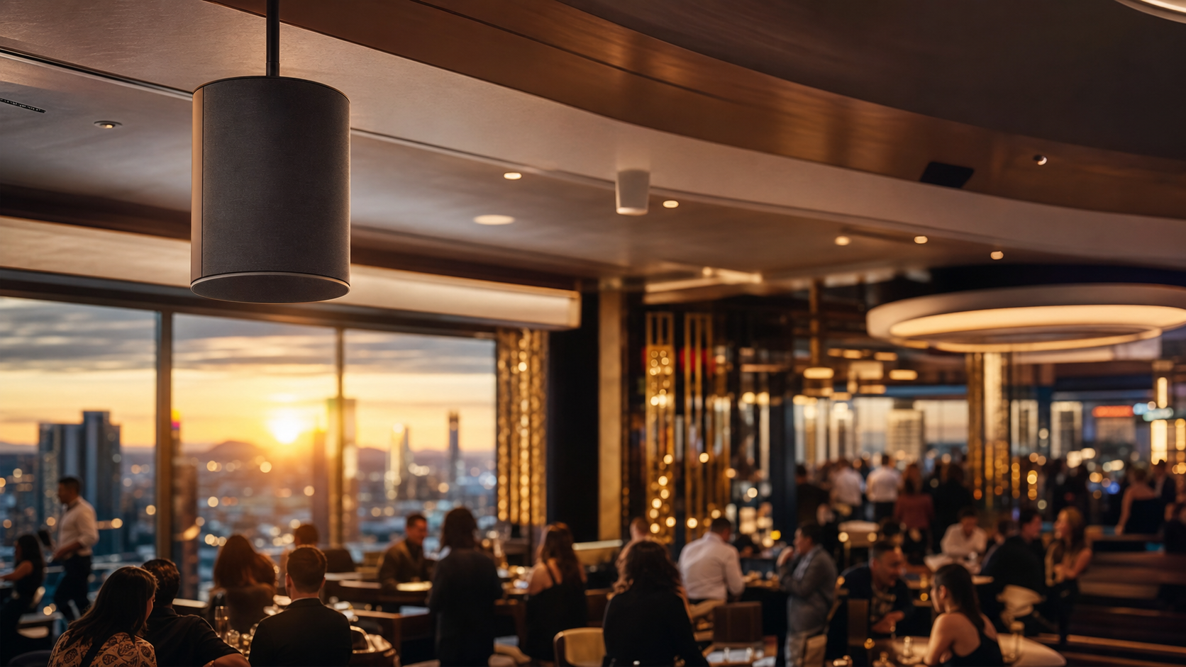 Upscale restaurant interior at golden hour with a ceiling pendant speaker